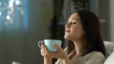 A woman relaxing with tea and practicing mindfulness.