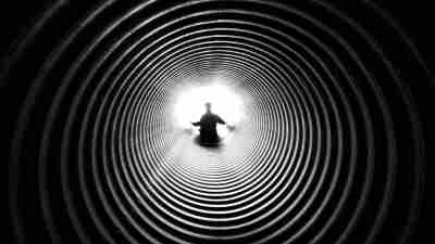 A boy with autism sitting alone in a tunnel