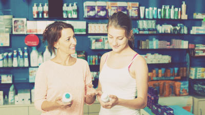 Mother helping her teenage daughter take responsibility for her own ADHD medication at a pharmacy
